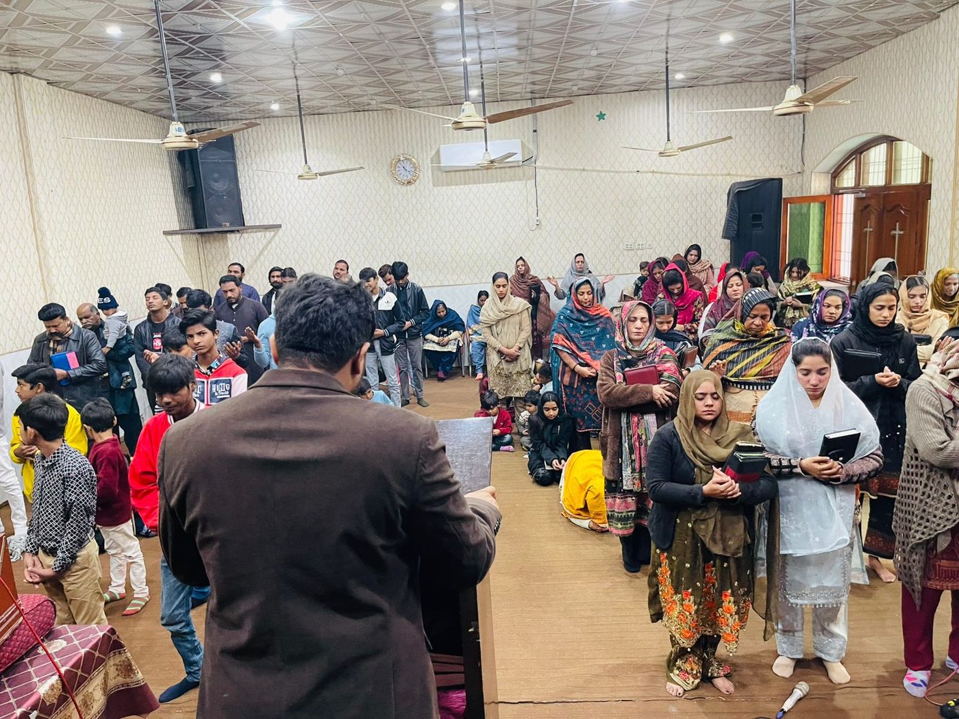 John Paul's congregation standing in worship in Pakistan